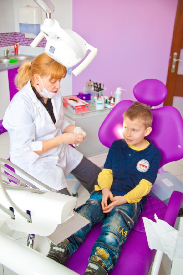 dentystka i siedzący na fotelu dentystycznym chłopiec