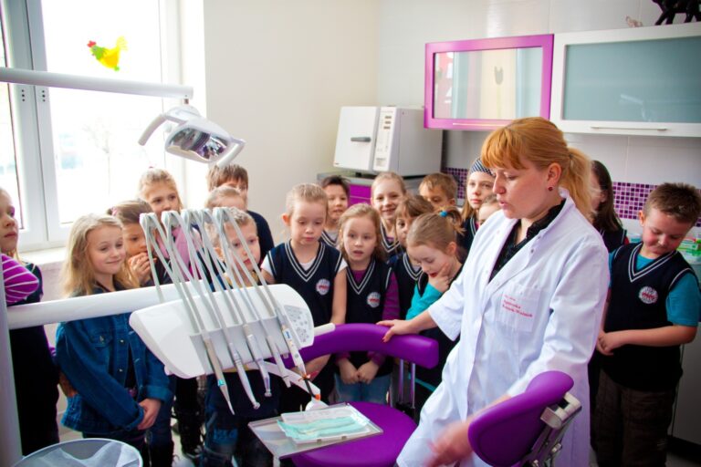 stomatolog pokazuje dzieciom narzędzia pracy